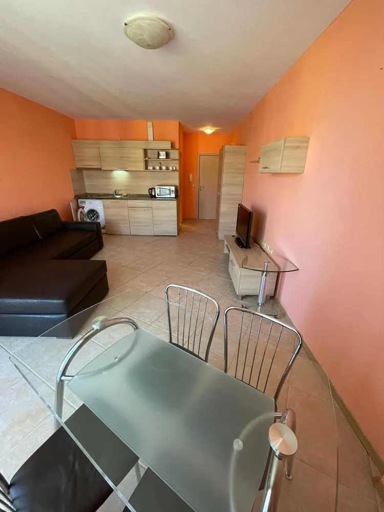 Kitchenette with cabinets, washing machine, and dining table