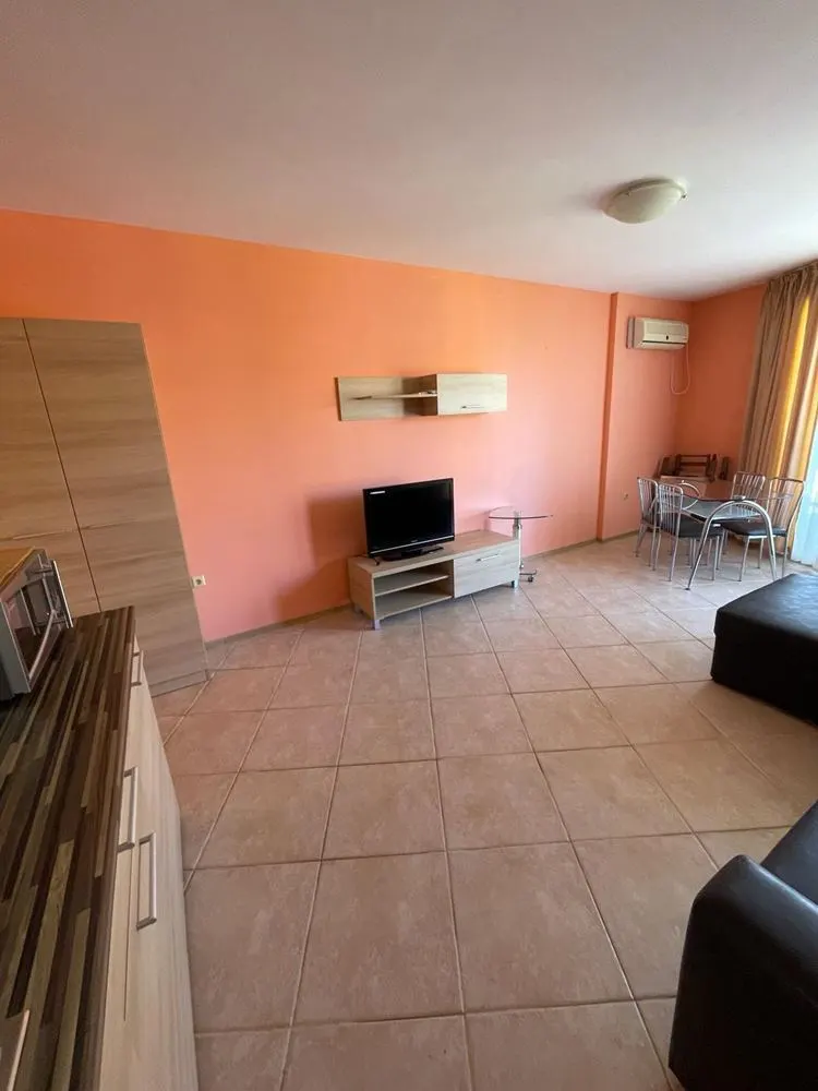 Studio living area with TV, AC unit, and dining zone