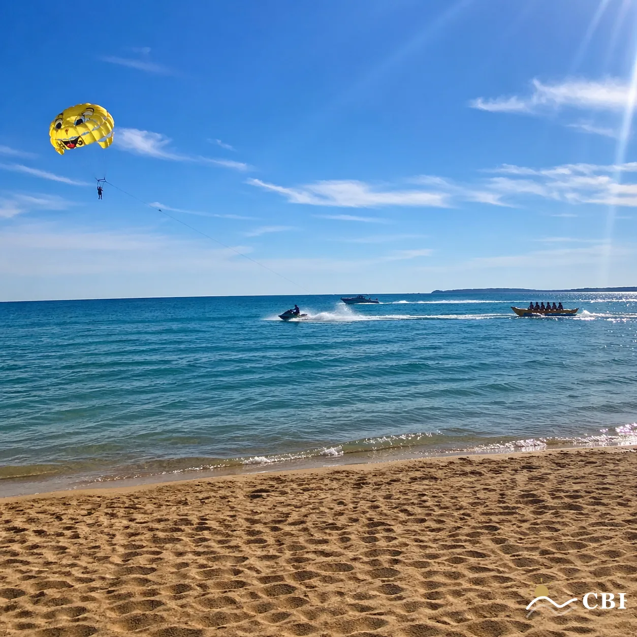 Summer afternoon watersports on the Black Sea at Sunny Beach, Bulgaria. Yellow parasail canopy floating above turquoise water, a jet ski cutting a white wake, and a banana boat being towed across the bay, all photographed from the pale golden sandy beach.